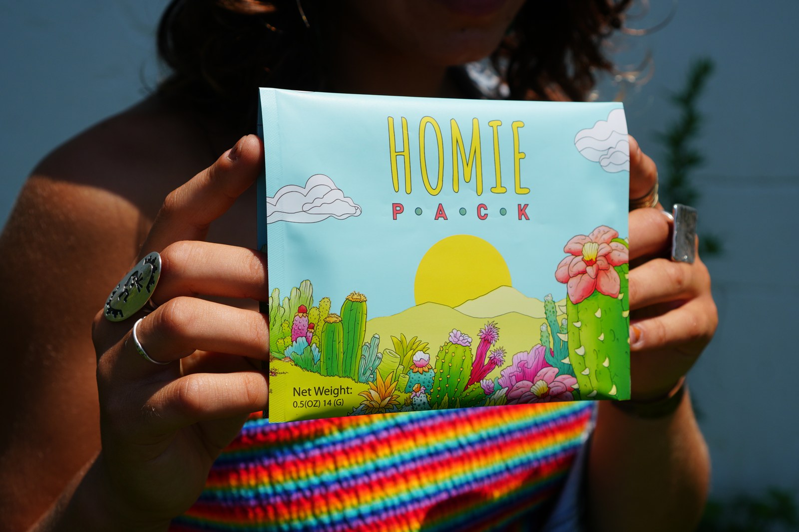 Person holding a Homie Pack ready-to-roll pouch in the sunlight